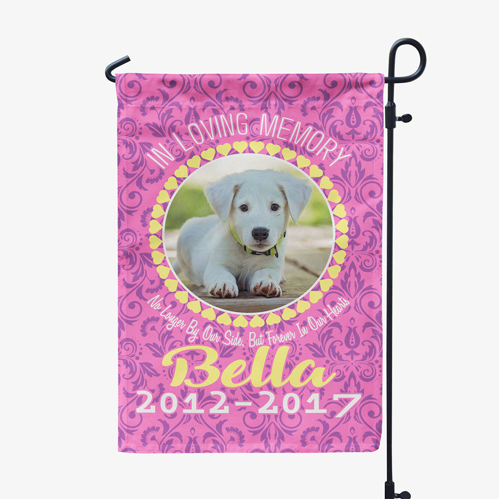 pink garden flag with text "in loving memory, no longer by our side, but forever in our hearts, Bella two thousand twelve to two thousand seventeen" with image of dog in circular frame