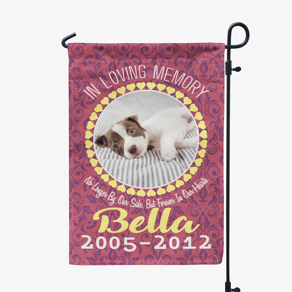 red garden flag with text "in loving memory, no longer by our side, but forever in our hearts, Bella two thousand five to two thousand twelve" with image of dog in circular frame