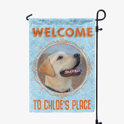 blue garden flag with text "welcome to chloe's place" with image of dog in circular frame