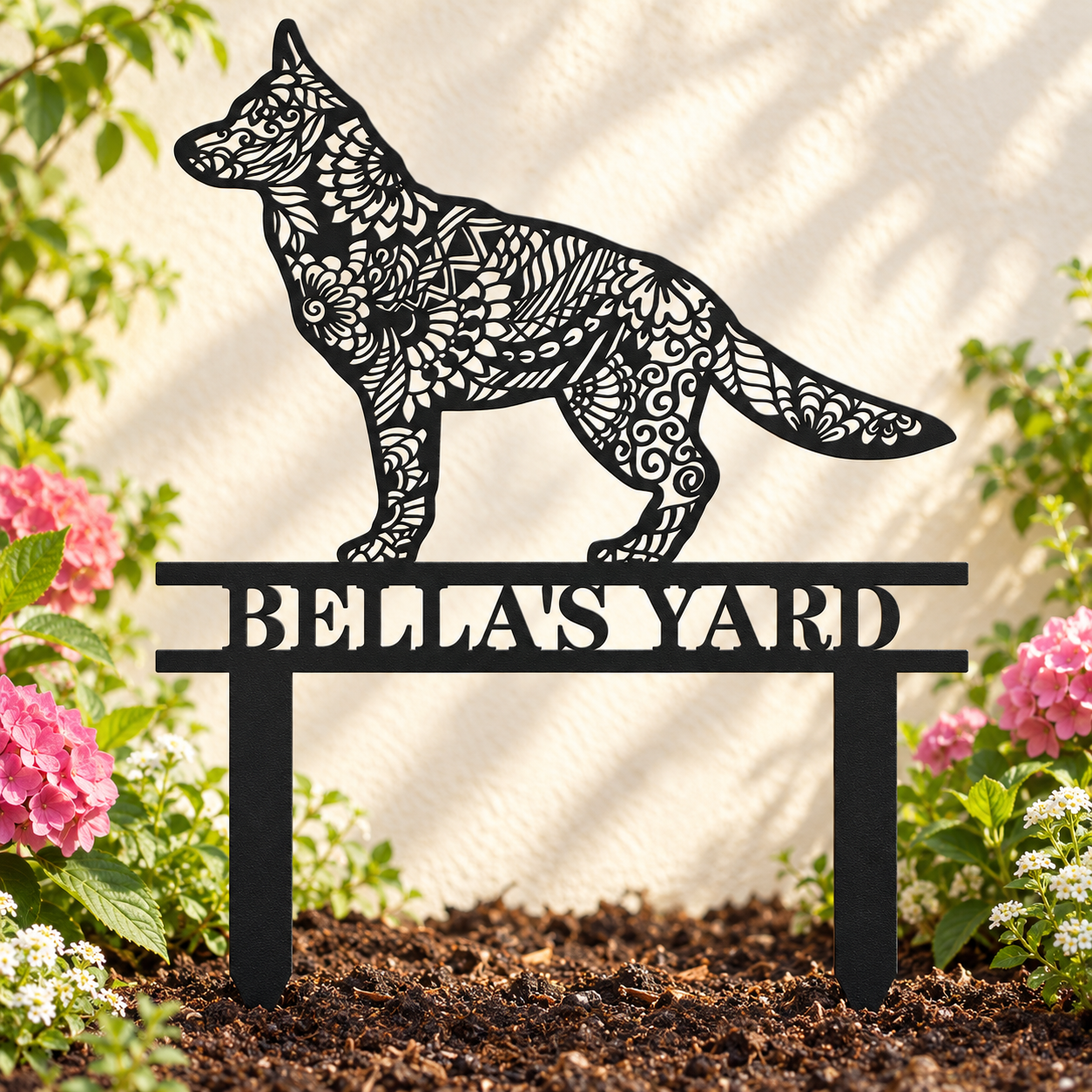 Black German Shepherd mandala garden stake reading Bella’s Yard among pink flowers