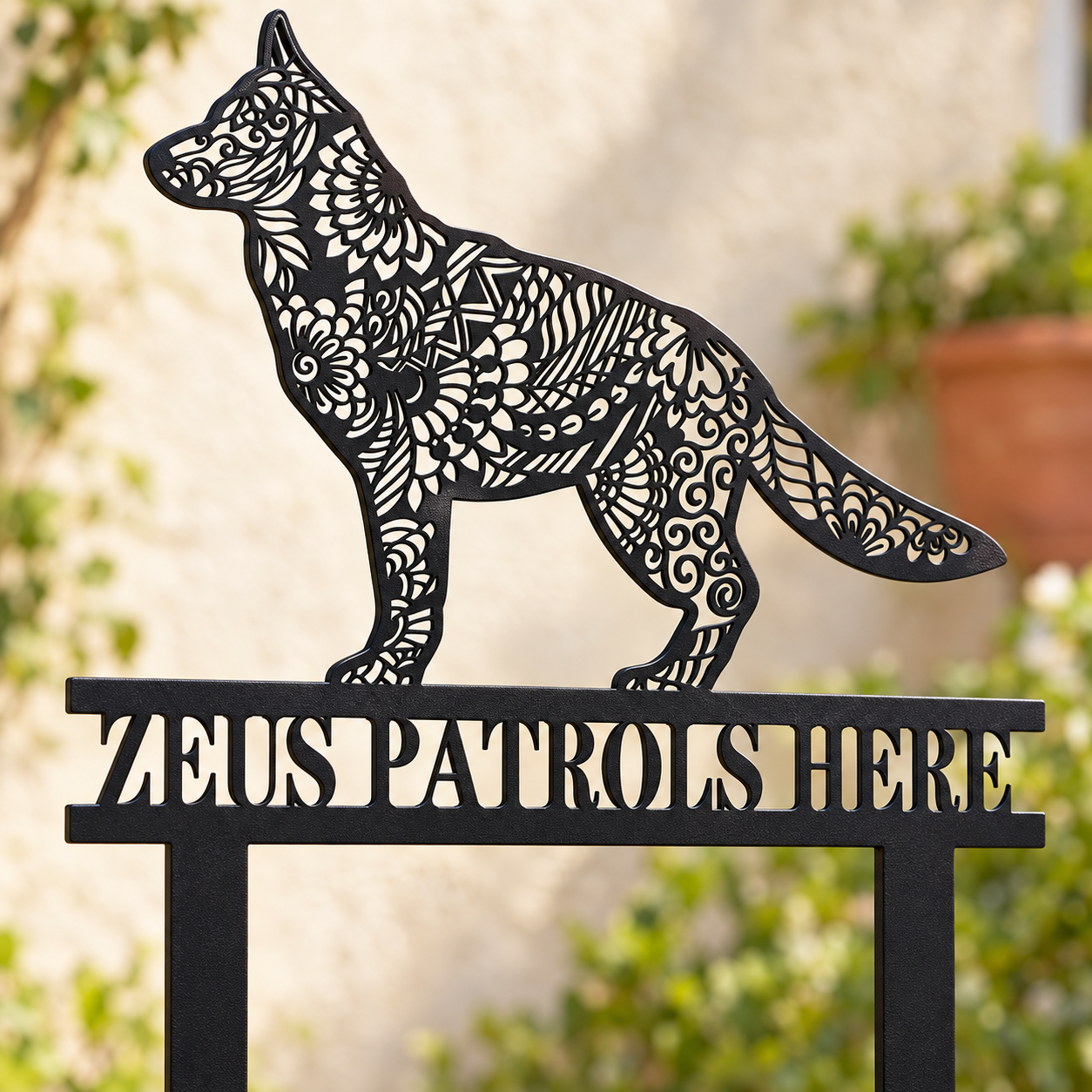 Close view of mandala cutouts and Zeus Patrols Here lettering on a German Shepherd garden stake
