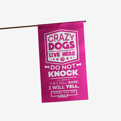 pink house flag with text "crazy dogs live here do not knock they will bark, i will yell, things will get ugly"