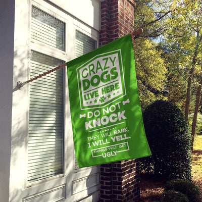 green house flag hung up on wall with text "crazy dogs live here do not knock they will bark, i will yell, things will get ugly"