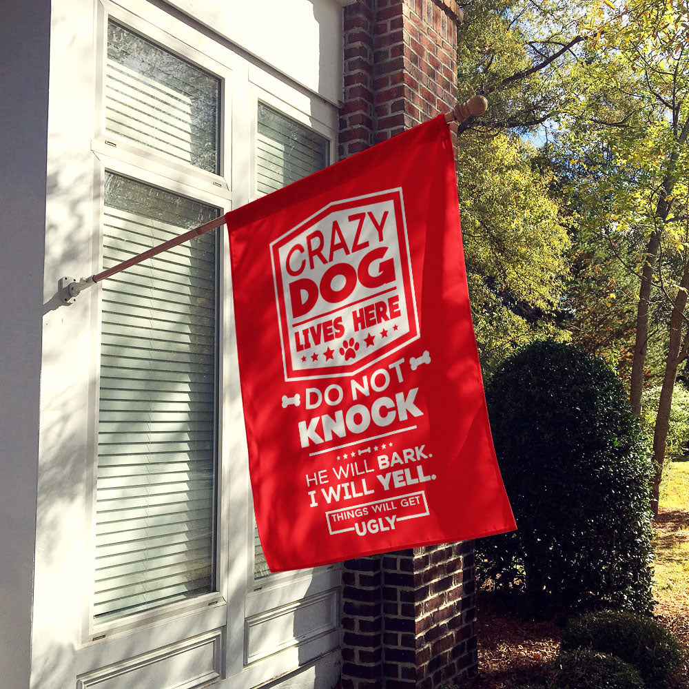 red house flag hung up on wall with text "crazy dog lives here, do not knock, he will bark, i will yell, things will get ugly"