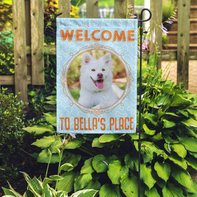 blue garden flag with text "welcome to bella's place" with picture of dog in circular frame
