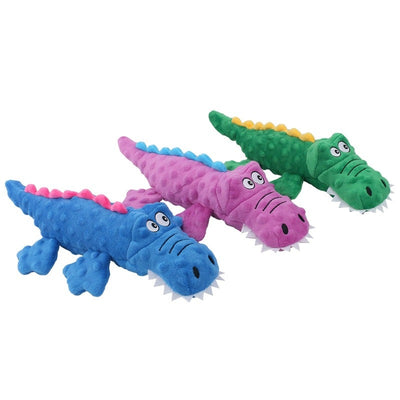 three crocodile-shaped dog toys, colored blue, pink, and green